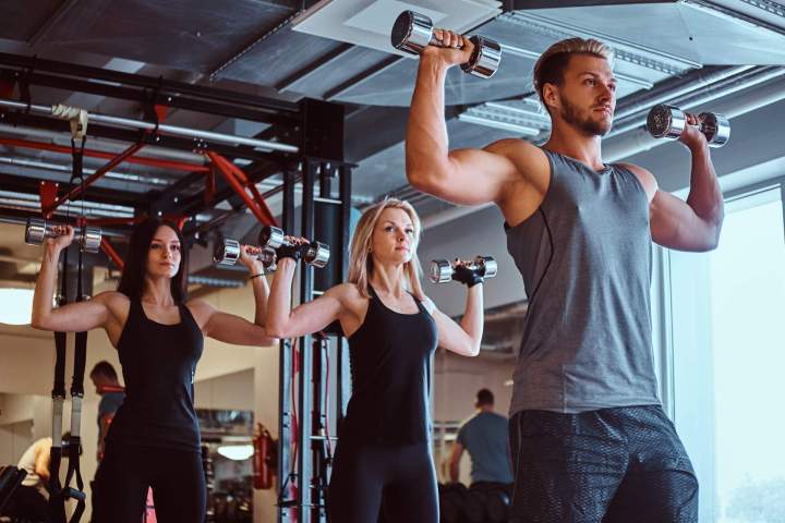 group people exercising with dumbbells fitness club gym